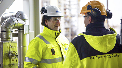 workers discussing at oil refinery